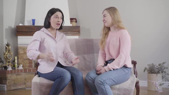 Portrait of Adult Caucasian Woman Talking Emotionally To Teenage Blond Daughter. Mother Sharing