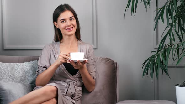 Woman Relaxing at Home During Morning Holding Cup of Coffee