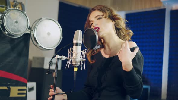 Woman singing in a recording studio. Female vocals. Professional recording studio.