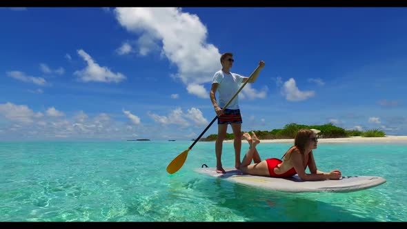 Young couple happy together on relaxing sea view beach voyage by blue green water and white sand bac
