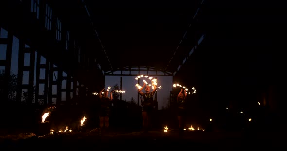 Four Women in Leather Clothes with Fire Dance and Show Fire Show a Man with a Flamethrower in the