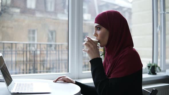 Gorgeous Arabic Girl is Drinking Cappuccino