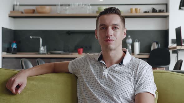 Smiling Man Is Resting While Sitting on Couch at Home