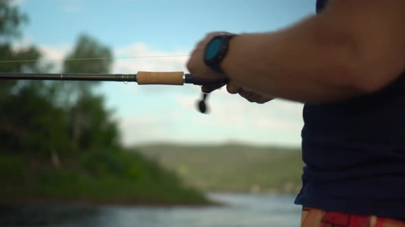 A Professional Fisherman Catches a Fish By Spinning