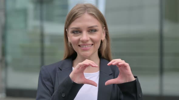 Businesswoman Showing Heart Shape By Hands Outdoor