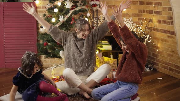 Mother and Daughters Playing Having Fun Laughing Throwing White Confetti at Home