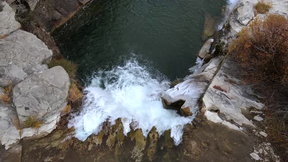 Aerial top-down view over Lundbreck falls in slow motion slowly ascending. Drone capturing autumn co