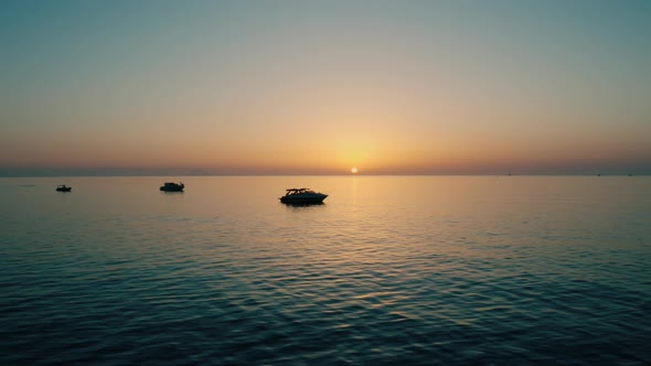 Silhouette of Boats at Sunset Over the Sea