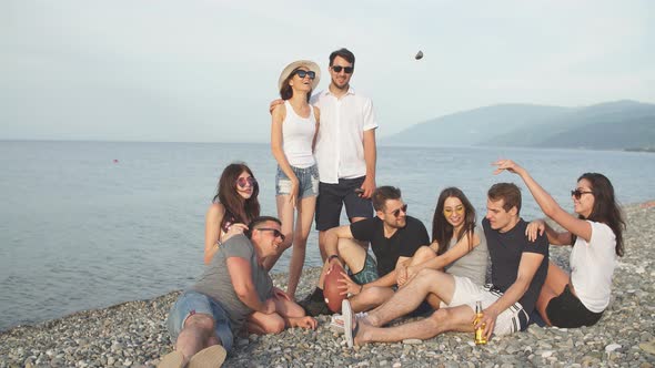 Cheerful Young People Spending Nice Time Together While Sitting on Beach