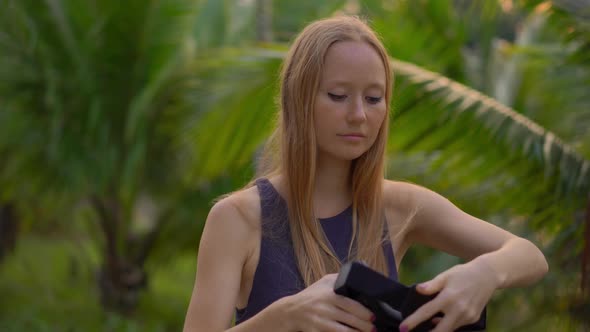 Closeup Shot of a Beautiful Young Woman Use a VR Headset in a Tropical Park. A Person Wearing a Vr