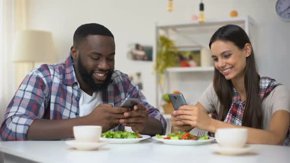 Mixed-Race Man and Woman Chatting Phone During Lunch, Lack of Communication