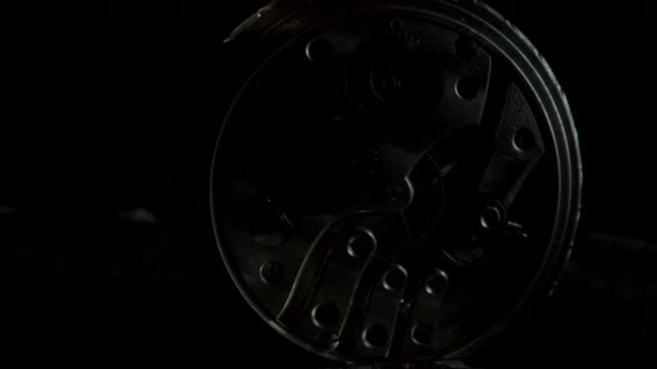 Two Antique Pocket Watches with a Working Clockwork in Darkness and in Light on Black Background