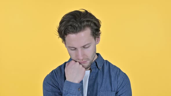 Tired Young Man Waking Up From Nap on Yellow Background