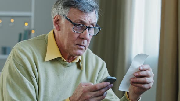 Caucasian Old 60s Man Senior Mature Grandfather Holding Smart Phone Using Mobile Ebank Application