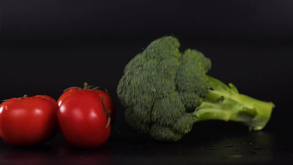 Close Up of Fresh Raw Organic Vegetable Produce Assortment of Broccoli Tomatoes Isolated on Black