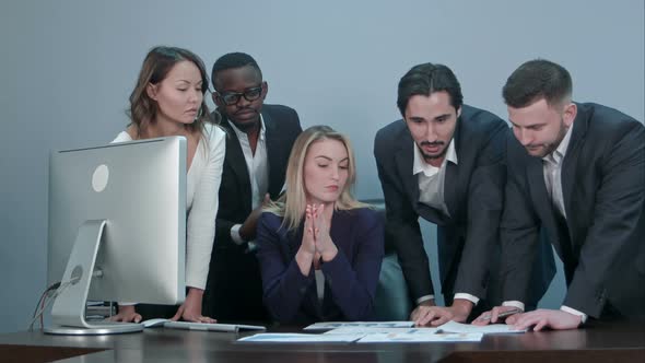 Group of Multiethnic Diverse Young Business People in a Meeting Standing Around a Table with Serious