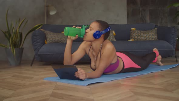 Relaxed Woman Drinking Energy Drink After Training