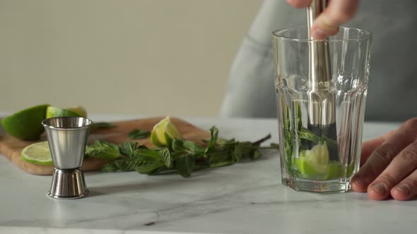 Bartender Prepares a Cocktail Mojito Using the Madler