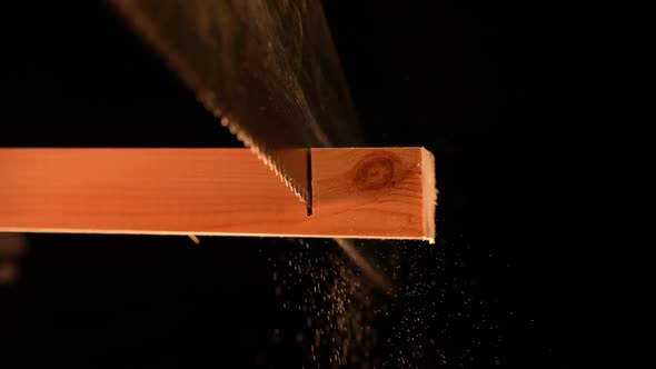 Man Carpenter Saws a Wooden Board with a Hand Saw