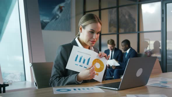 Young woman in a suit working with a laptop in the office