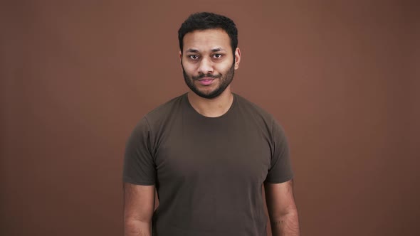 Serious Eastern Man Saying No and Gesturing with His Finger to Camera Brown Studio Background