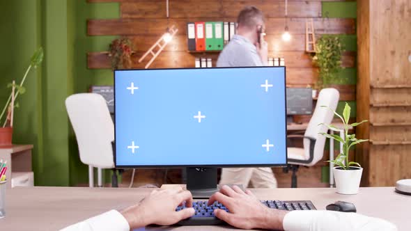 POV Shot of Man Typing on Computer with Green Screen