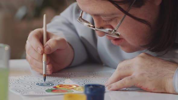 Man with Down Syndrome Drawing on Paper with Gouache