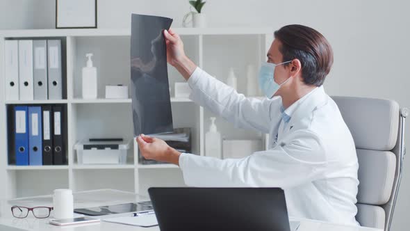 Professional medical doctor working in hospital office using computer technology.