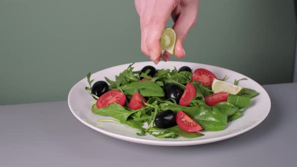 Dressing Fresh Salad with Vegetables on Big White Plate