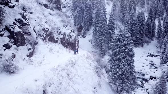 A Group of People Walk Through a Snowy Gorge