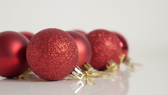 Red color assorted Christmas baubles close-up 4K tilting footage