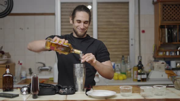 Caucasian Barman Using Jigger to Put Alcohol in Cocktail Shaker Preparing Cocktail for Friends