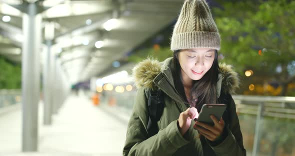 Asian Woman use of mobile phone in city at night
