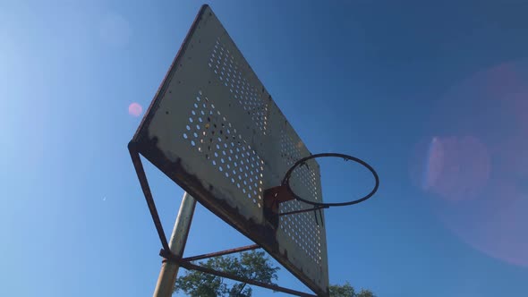 Rusty basketball hoop on inner city basketball court no net 4K