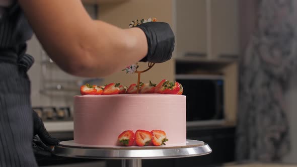 Finishes Decorating Birthday Cake with Fresh Strawberries