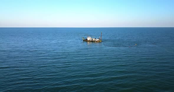 Ship to Suck Up the Sand Near a Dike