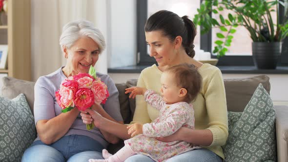 Mother and Daughter Giving Grandmother Flowers
