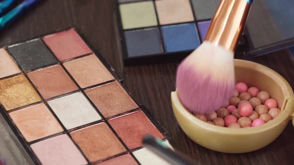 Makeup Brush Applying Cosmetic Powder Balls on Vanity Table Close Up