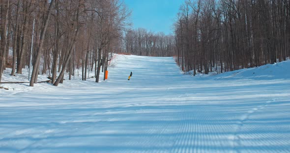 Man Rides a Snowboard on a Snowy Track