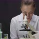 Young Microbiologist Works on Research Looks Through Microscope in Laboratory - VideoHive Item for Sale