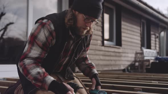 Carpenter Working Outdoors Using Spirit Level