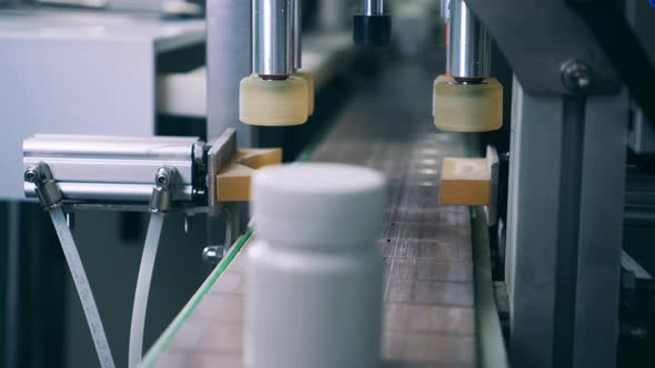 Factory Conveyor is Sealing Plastic Pill Bottles