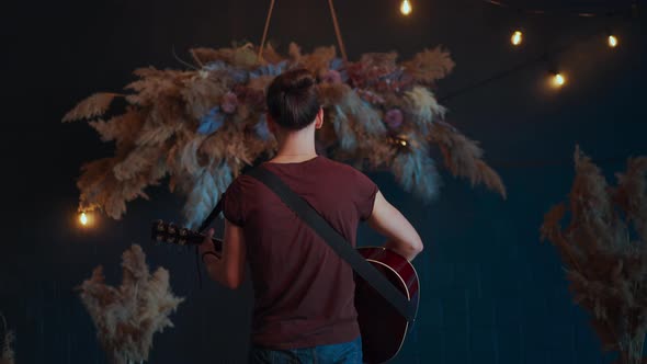 Male Musician Turns Around Playing Acoustic Guitar