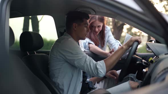 Side View Man on Driver's Seat Talking with Smiling Woman Asking Route