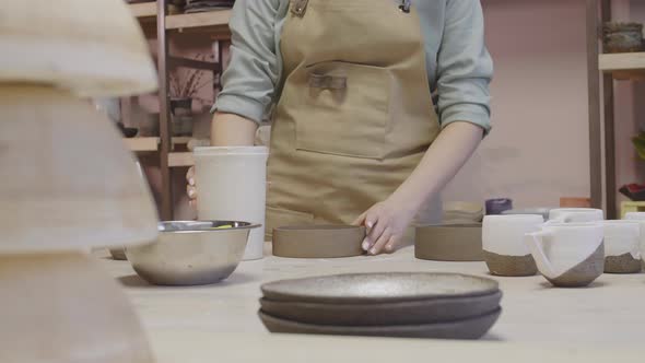 Good-looking Craftswoman Painting Bowls in Pottery