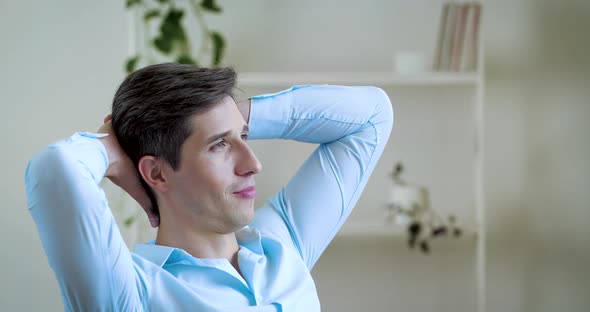 Portrait Adult Relaxed Male Sitting in Office Room with His Hands Folded Behind His Head, Dreaming