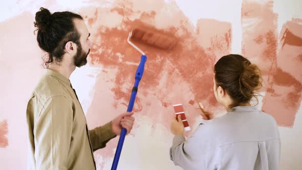 Young Woman in Shirt Approaches Bearded Guy Colouring Wall