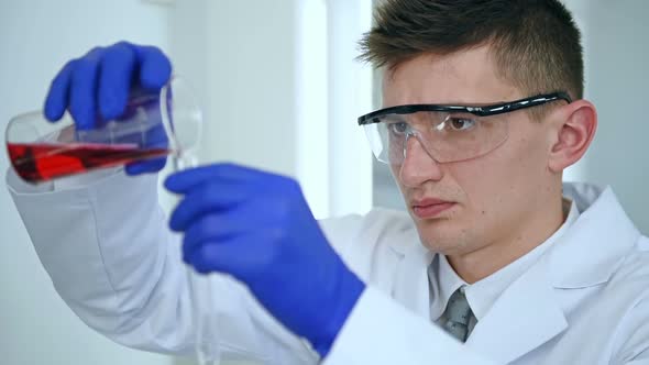 Scientist Dropping Red Liquid Substance