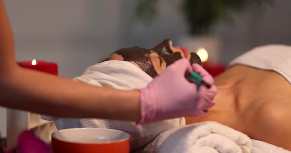 A Woman is Given a Chocolate Mask on Her Face Closeup