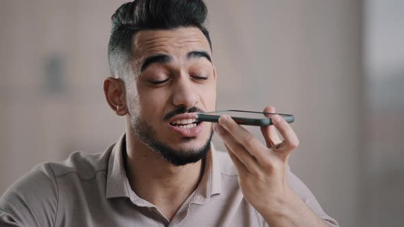 Arabian Millennial Businessman Entrepreneur Sitting at Workplace Talk on Speakerphone with Friend